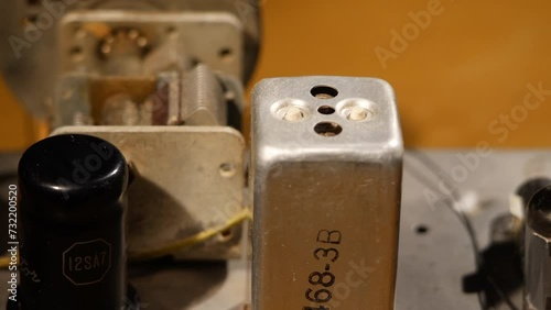 High angled pan shot of the insides of an old radio with vacuum tubes