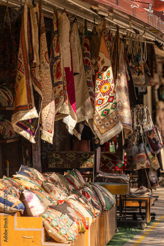 close-up of an oriental bazaar, a store with various scarves, carpets and pillows with ornaments