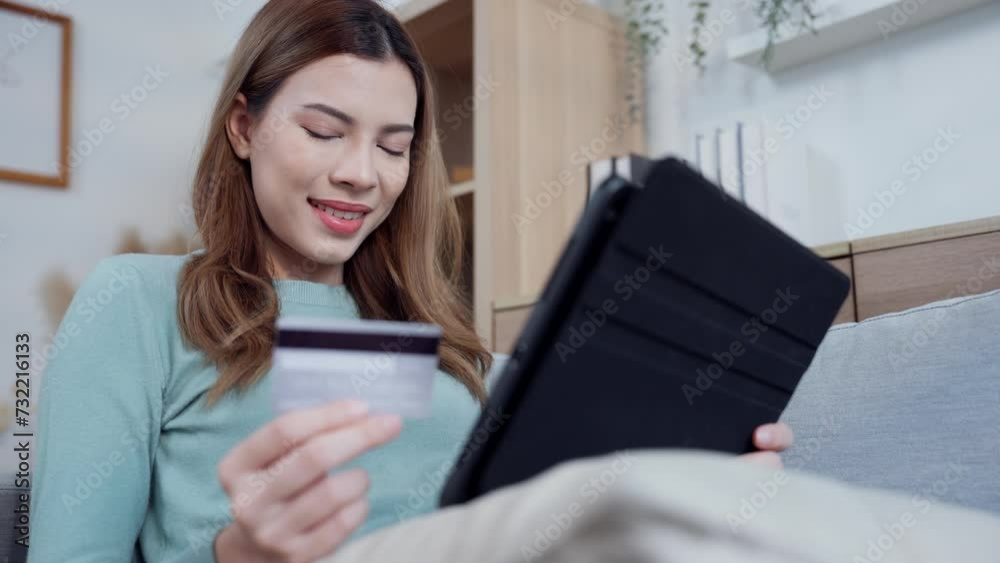A woman express on her face with cheerful, conveying a sense of satisfaction and happiness with her online shopping and successful credit card transactions. A woman express on her face with cheerful, conveying a sense of satisfaction and happiness with her online shopping and successful credit card transactions.