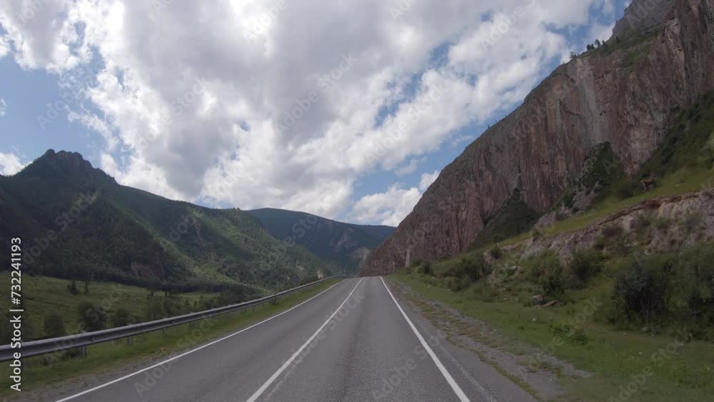 Driving in a car along the mountain road of the Chuya Highway or the Chuysky Trakt in Altai. Siberia, Russia Driving in a car along the mountain road of the Chuya Highway or the Chuysky Trakt in Altai. Siberia, Russia