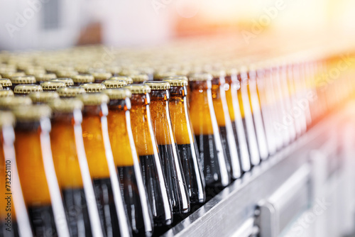 Automated brewery conveyor, Brown glass beer bottles with sunlight. Banner drink alcohol industry food manufacturing