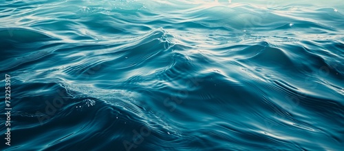 A detailed view of an electric blue painting depicting fluid waves in the ocean, showcasing the natural landscape and marine biology. © AkuAku