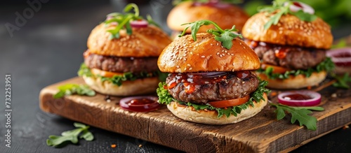 Three burgers are placed on a cutting board, a staple food commonly used in recipes and cuisines. This dish can be paired with leaf vegetables and served as a sandwich using tableware.
