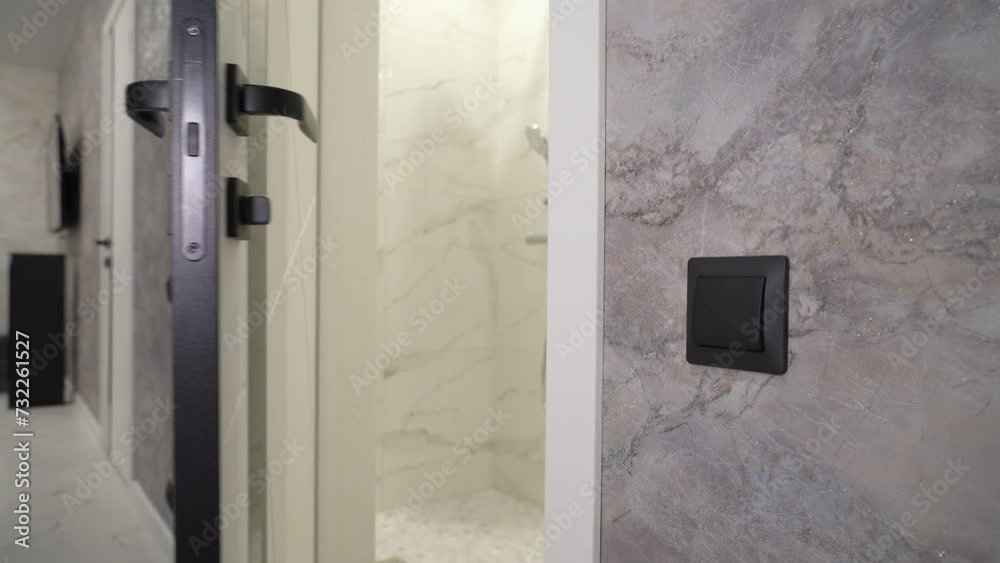 Woman opens the door with a black handle and enters the bathroom Woman opens the door with a black handle and enters the bathroom
