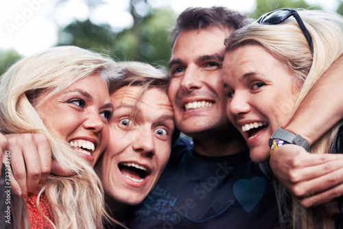Face, smile and hug with excited friends closeup outdoor in nature together for travel, festival or adventure. Party, energy or wow with man and woman group laughing in forest or woods in summer