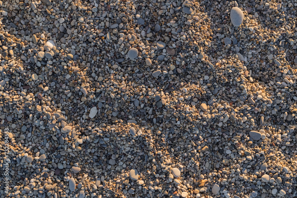 Smooth round pebbles on a Mediterranean beach with sunset light Smooth round pebbles on a Mediterranean beach with sunset light
