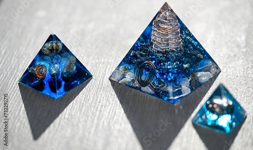Isolated close up of three beautiful blue orgone generator pyramids- Israel photo