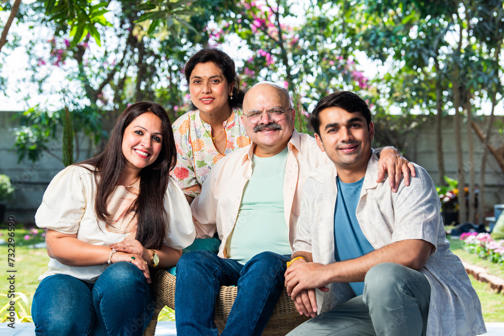 Fototapeta premium Outdoor portrait of cheerful Indian family sitting on stairs.