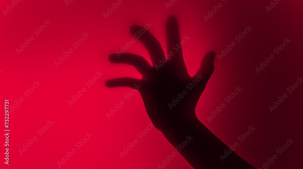 Hand silhouette on red background. Blurred human hand shape out of focus