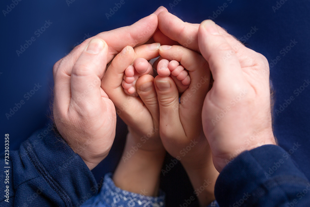 legs of a newborn in the hands of parents legs of a newborn in the hands of parents