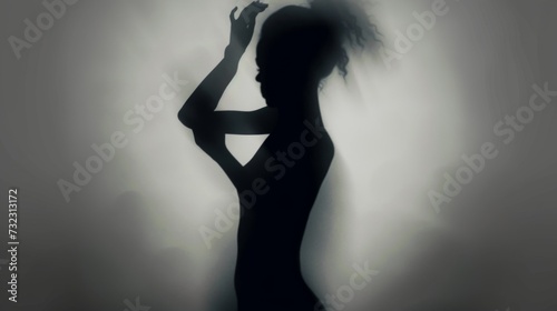 Female blurred silhouette on a white background. Elegant outline of a woman in motion out of focus