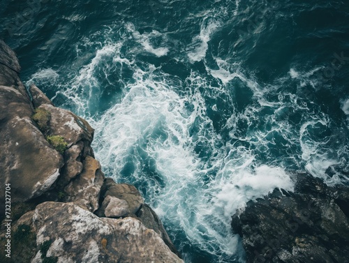 Top-down view of a rocky coastline with crashing waves