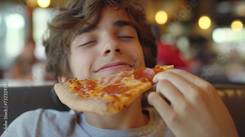 Teenager eating a slice of pizza with pleasure