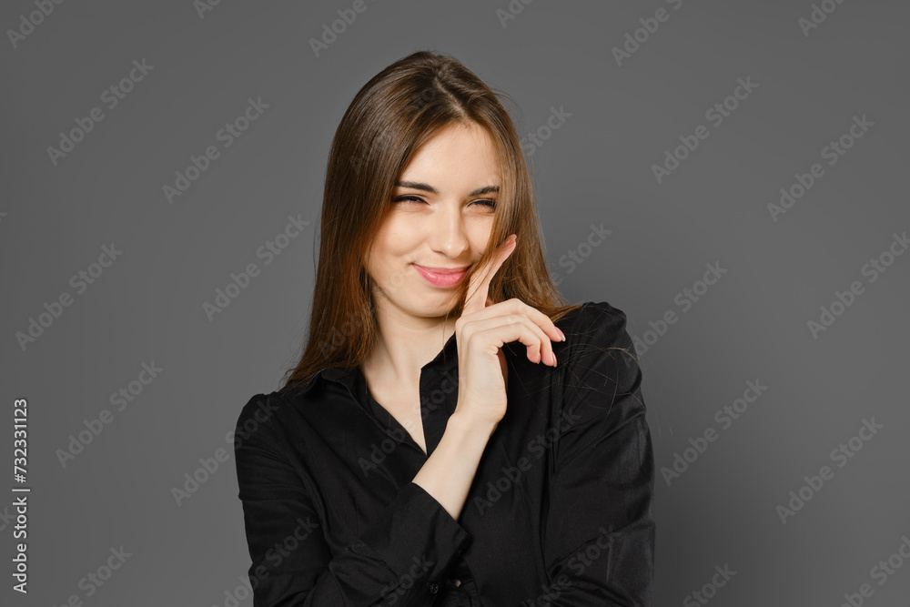 Playful young woman winking with tricky smile Playful young woman winking with tricky smile