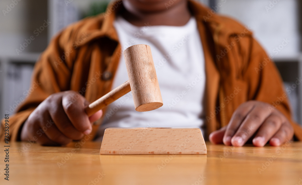 Hand of black boy holding gavel, Child protection law, Juvenile Court, Dream career concept. Hand of black boy holding gavel, Child protection law, Juvenile Court, Dream career concept.
