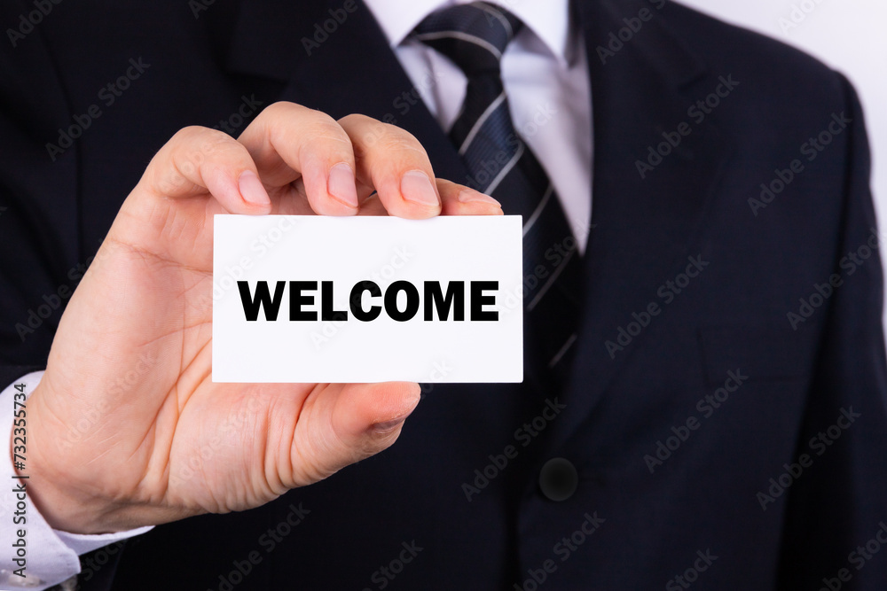 Businessman holding a card with text Welcome Businessman holding a card with text Welcome