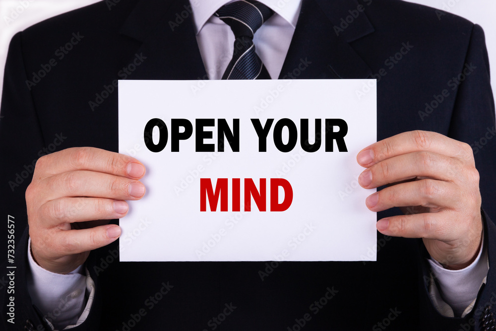 Businessman holding a card with text open your mind Businessman holding a card with text open your mind