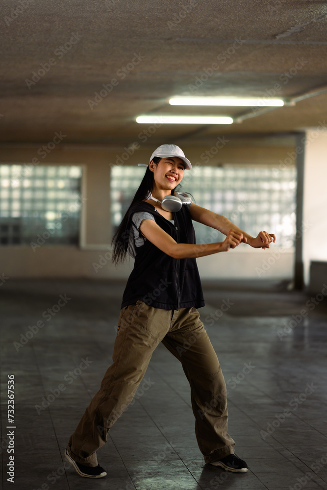 Full length of talented female street dancer dancing in parking garage