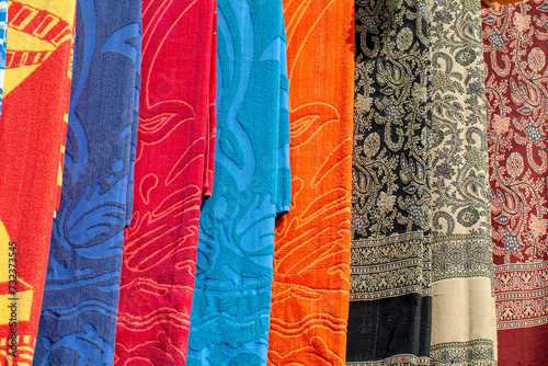 Street bazaar on an Egyptian street with with colorful towels and decorative shawls in oriental patterns, Dahab, Egypt