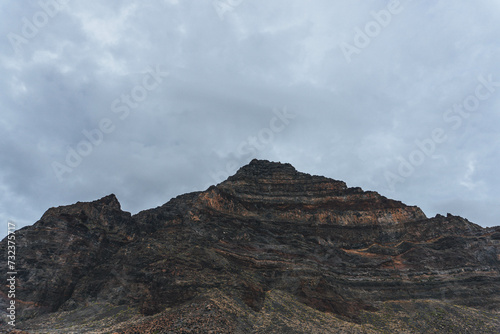 Very rocky volcanic formations on island forming a lunar landscape with clouds behind in moody atmosphere 