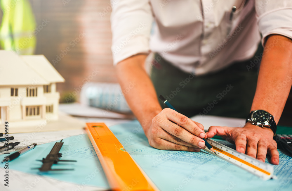 architecture, architect, construction, engineer, project, design, blueprint, house, model, plan. engineer use pencil and ruler to measure architects on the desk with a blueprint in the office. architecture, architect, construction, engineer, project, design, blueprint, house, model, plan. engineer use pencil and ruler to measure architects on the desk with a blueprint in the office.