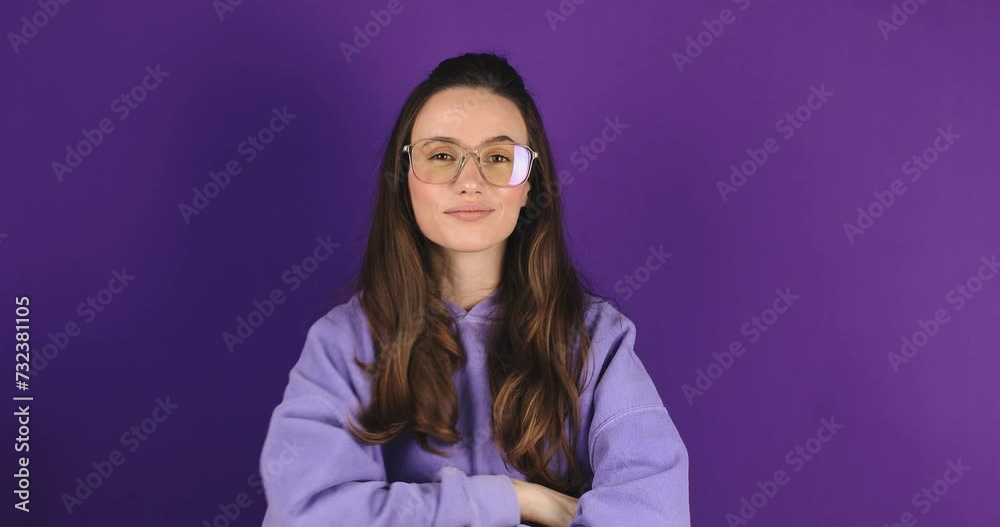 Lady boss. Close up portrait of young confident brunette hair woman putting on her eyeglasses, looking seriously at camera. Career and feminism concept. Eyesight problem isolated on purple background. Lady boss. Close up portrait of young confident brunette hair woman putting on her eyeglasses, looking seriously at camera. Career and feminism concept. Eyesight problem isolated on purple background.