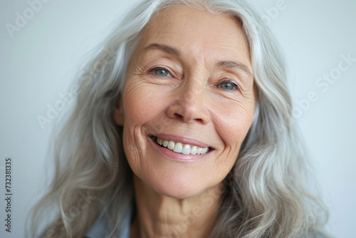 Senior woman smiling against neutral background. Ageing gracefully.