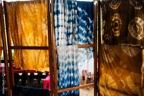 Thai craftsmanship artist working batik ikat tie dye cotton and silk fabric with natural color in handmade handicrafts local studio in Baan Phu Chuang village at Ban Rai city in Uthai Thani, Thailand