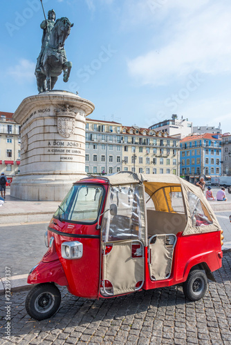 Tuk tuk restacionado en la plaza de Figueira, cerca de la estatua del rey Joao I en Lisboa, Portugal