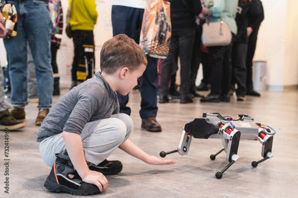 children play with a robot dog, close-up. High quality photo children play with a robot dog, close-up. High quality photo