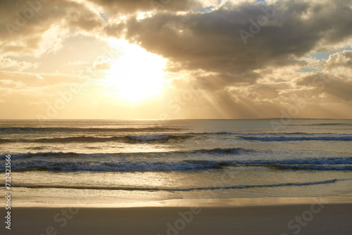 Sunset  beach or ocean water with clouds in summer  vacation or sunshine at background of horizon. Sea  waves or sand on land at twilight outdoor in nature  seashore or coastline to travel on holiday