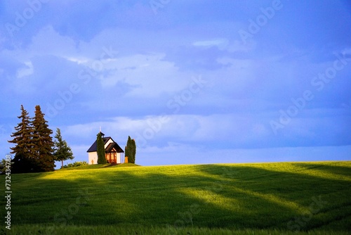Malerisch blauer Himmel und leuchtend gelb grünes Gras vor der Schindelbergkapelle in Östringen
