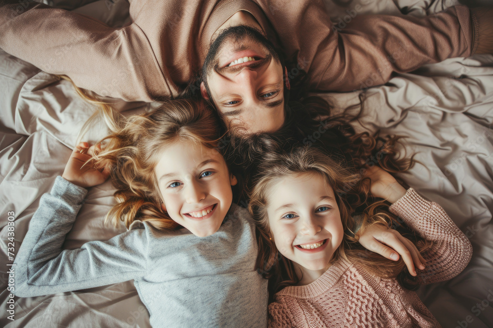 Portrait of a happy family lying in bed