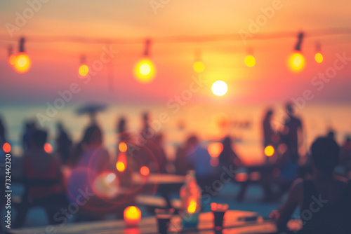 Blurred people having sunset beach party in summer vacation.