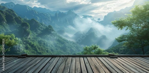Wooden decking with a breathtaking view of mist-covered mountains and lush greenery at sunrise