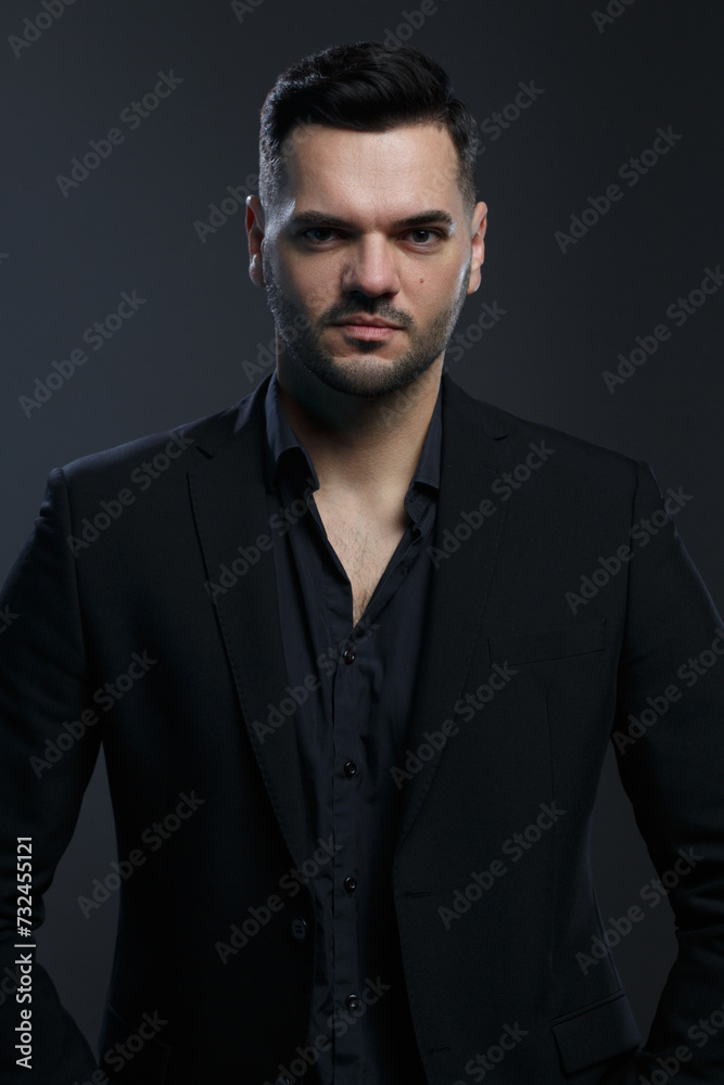 Attractive man in an elegant black suit  on a dark background.