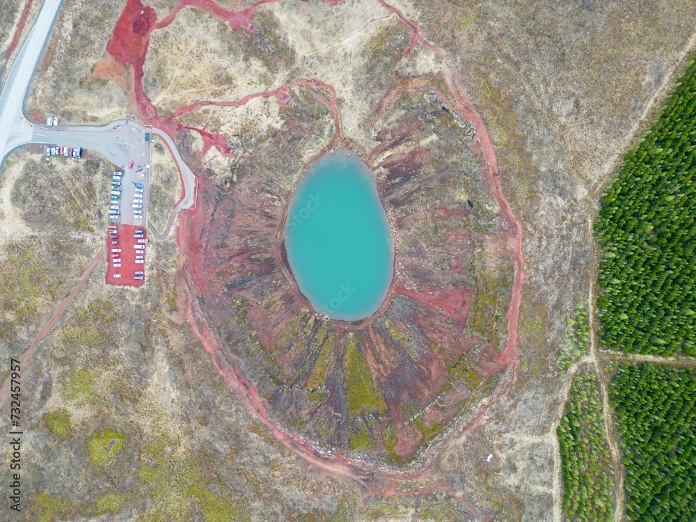 Aerial view of a stunning small blue lake situated in a rocky and mountainous terrain