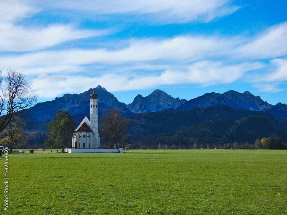 St Coloman's church building in greenery field surrounded by mountains St Coloman's church building in greenery field surrounded by mountains