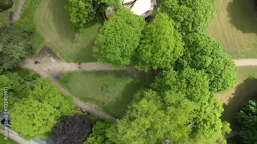 Drone view over a road between green fields and residential areas