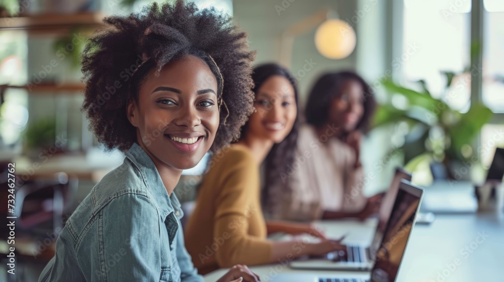 Young African American female businesswomen start-up looking camera working with colleagues partners sitting in cozy workplace meeting room, modern home office with technology laptop computer on table