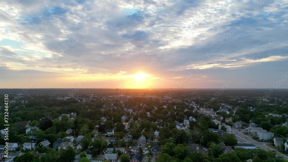 Aerial of the golden sunset shining over a town in the blue cloudy sky Aerial of the golden sunset shining over a town in the blue cloudy sky