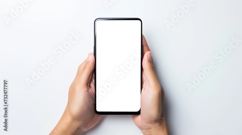 Close-up of hands holding smartphone with blank white screen on blank background photo