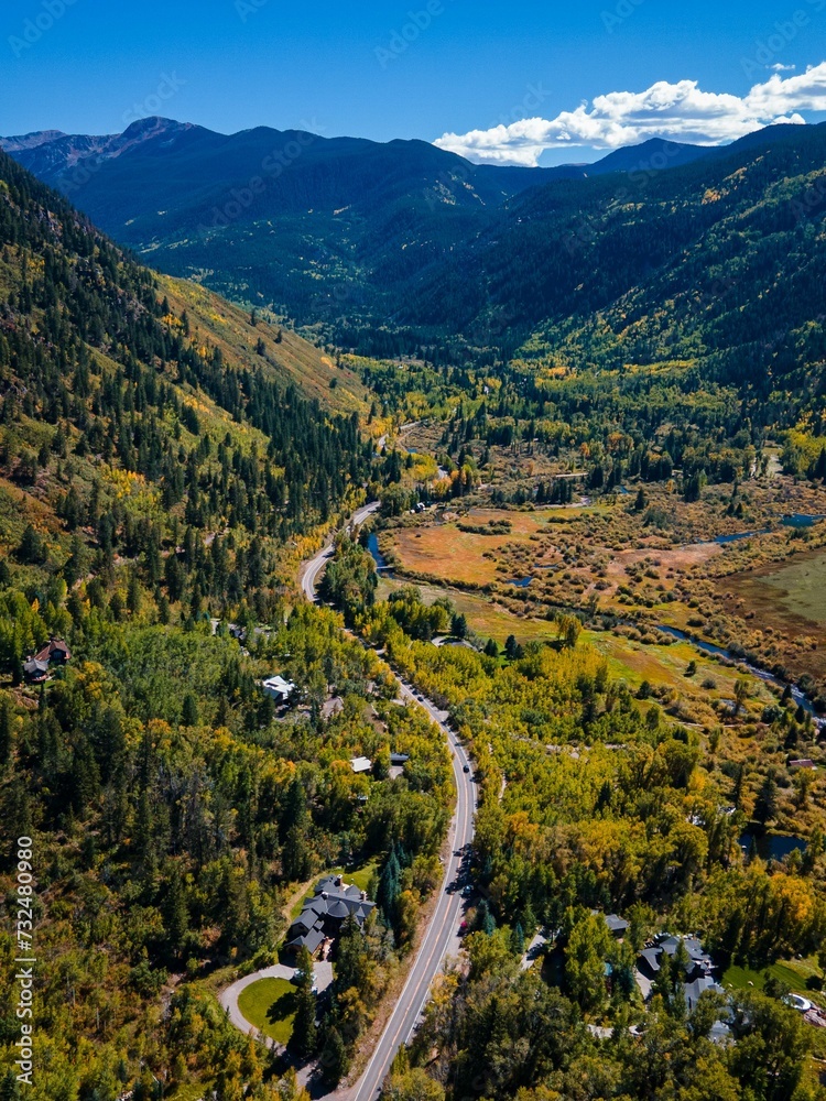 Aerial shot of a scenic valley in mountains featuring a winding river snaking through the landscape