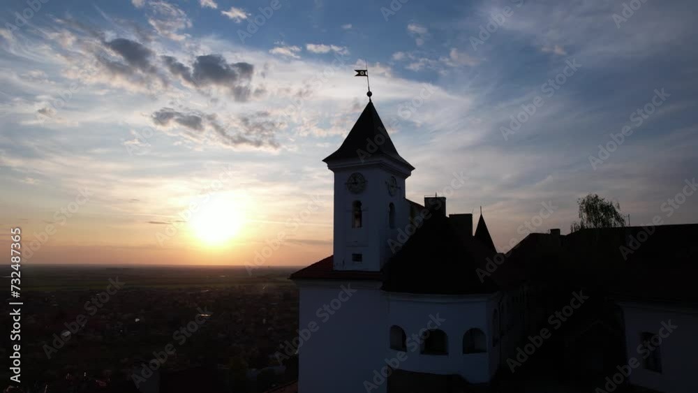 Sunset with a silhouette of Mukachevo Castle and it's clock tower with beautiful sky aerial footage