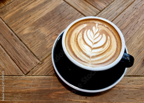 Sideway shop coffee, a cup of hot latte art coffee on wooden background.