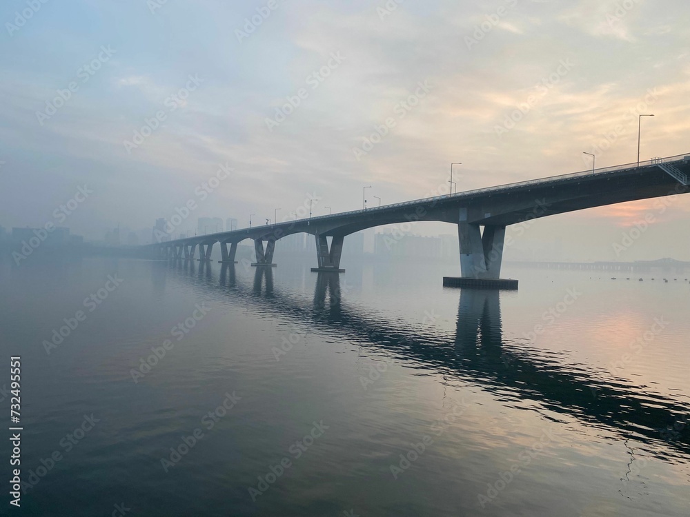 Scenic view of a foggy bridge spanning over a tranquil body of water. Seoul, South Korea.