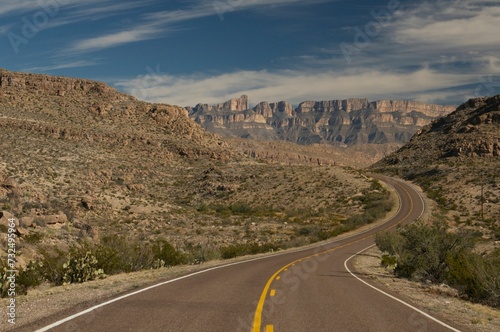Scenic view of a long highway stretching across the horizon with barren desert