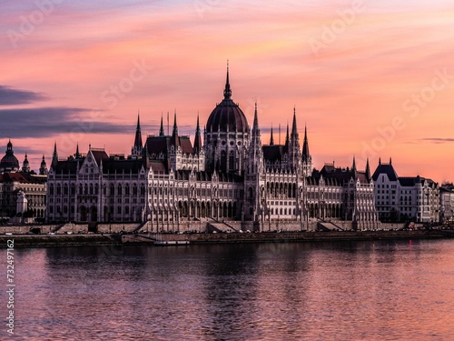 Hungarian Parliament Building on the banks of the Danube River at pink sunset © Wirestock