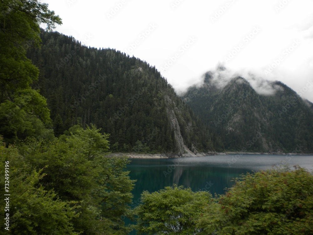 Breathtaking view of lush green mountains surrounding a picturesque alpine lake. Breathtaking view of lush green mountains surrounding a picturesque alpine lake.