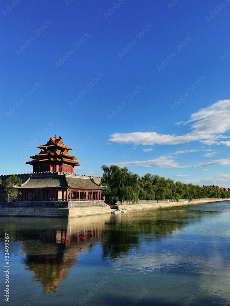 Corner tower of the Imperial Palace in Beijing, China on a sunny day against a cloudy blue sky